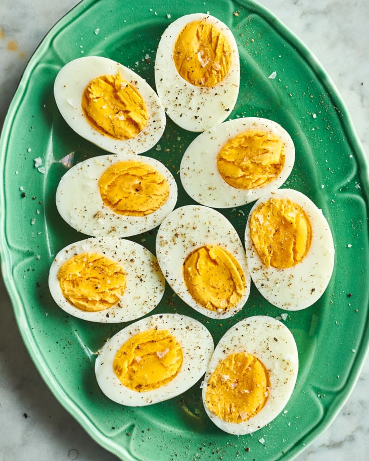 air fryer hard boiled eggs on a green plate with salt and pepper