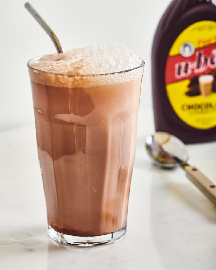 diner style egg cream on a table next to syrup