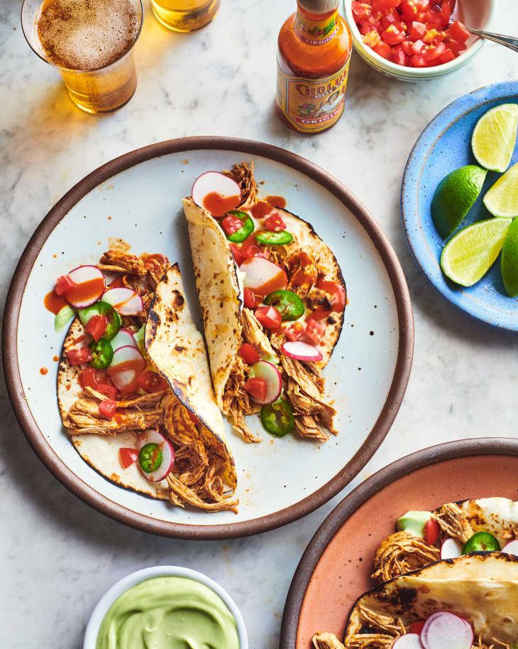 instant pot chicken tacos on a plate near limes and guac