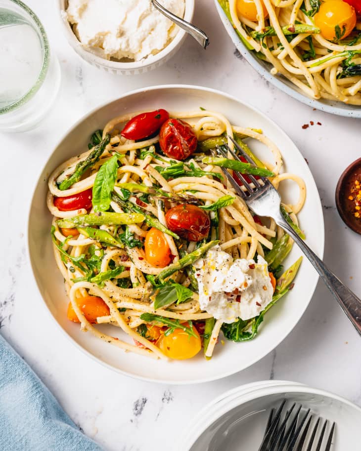 ultimate spring pasta in a bowl on a table with other dishes near it