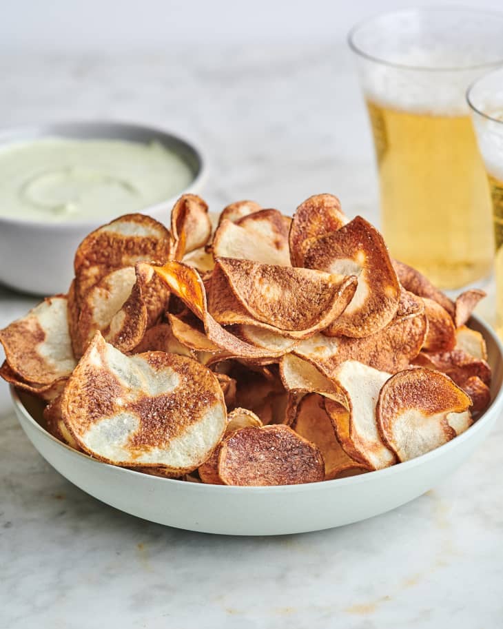 air fryer chips in a bowl next to  a beer
