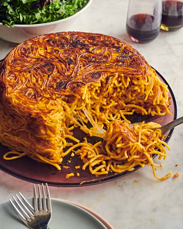 persian makaroni on a plate with a section missing and forks nearby