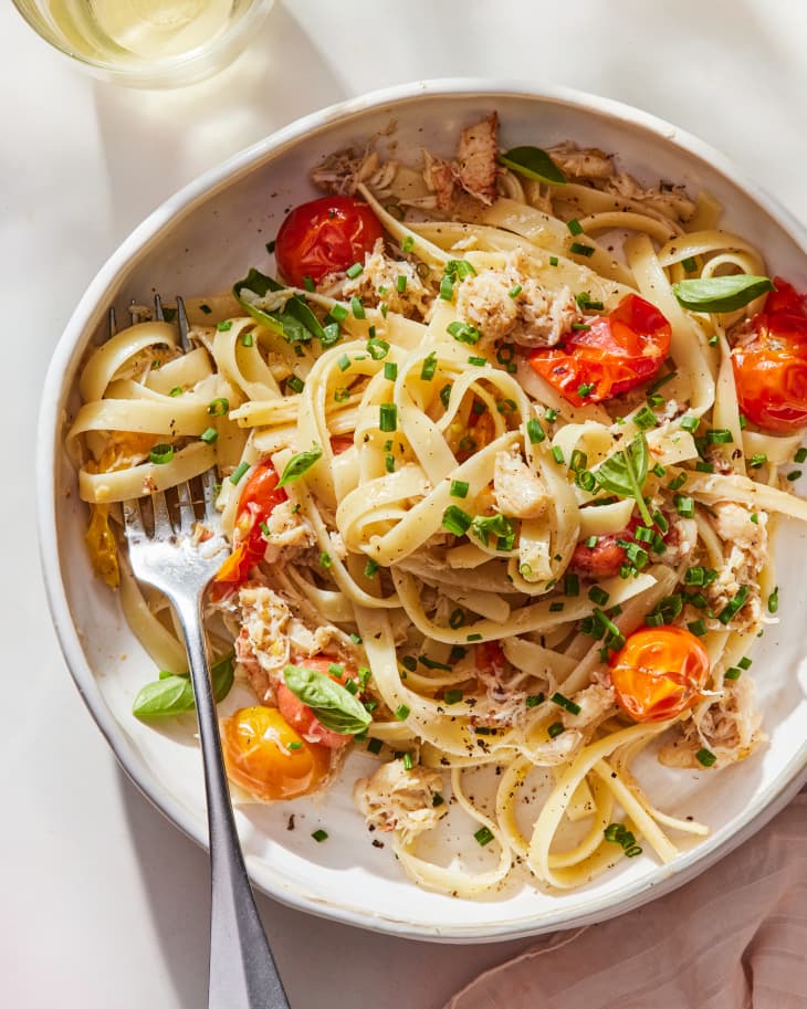 Crab pasta with brown butter and cherry tomatoes in bowl.