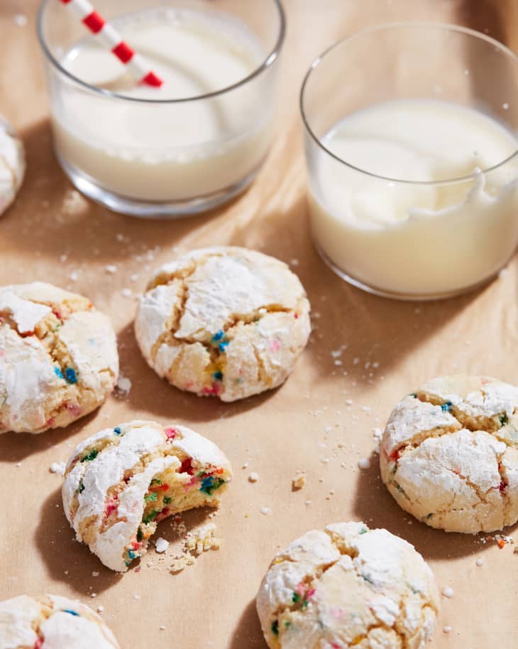 cookies and milk on parchment with one taken a bite out of it