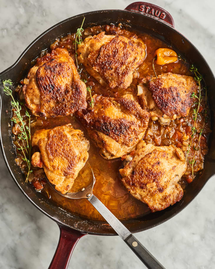 chicken in cast iron pot with a spoon in it