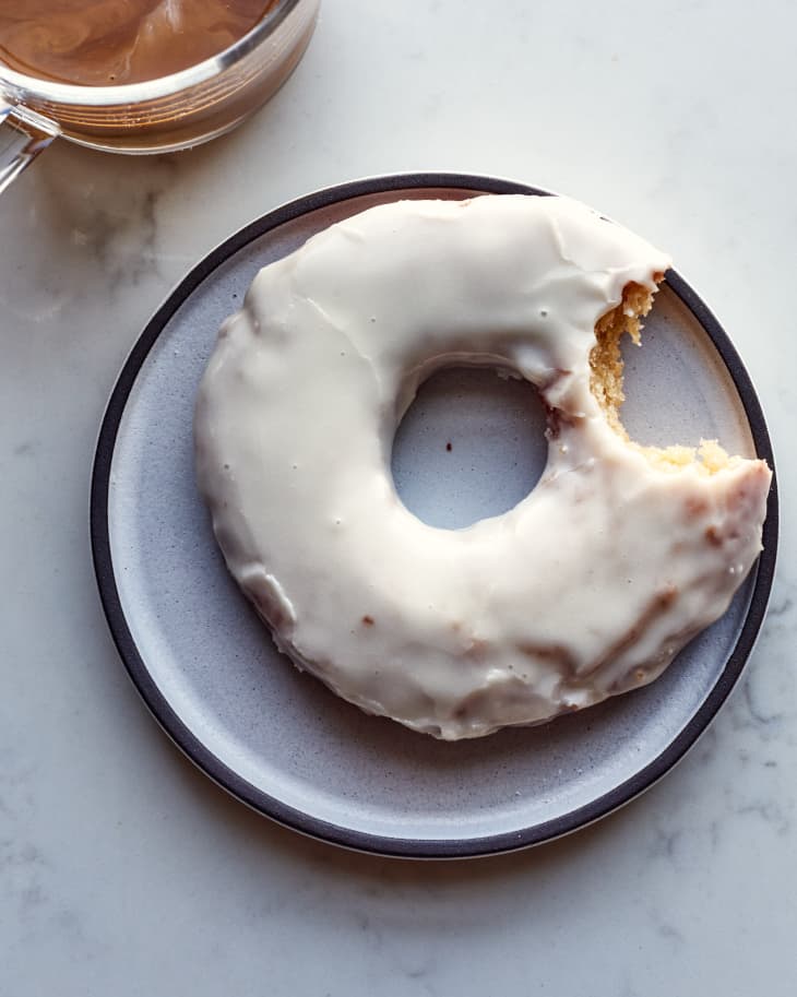 sour cream doughnut on a plate with a bite taken out