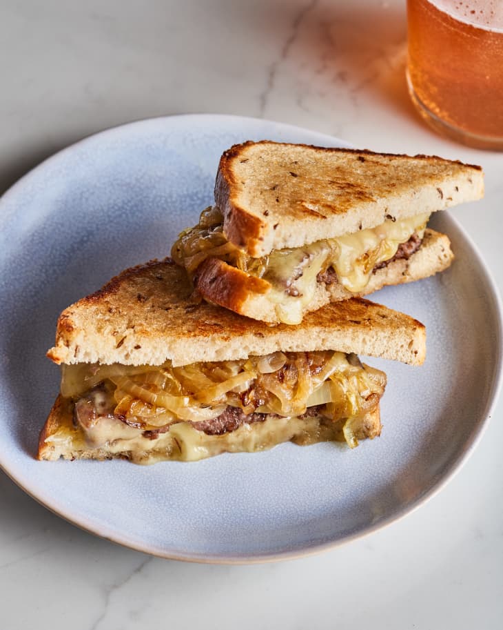 patty melt on a plate with beer