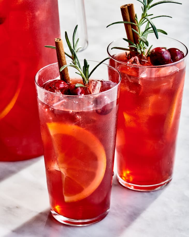 two glasses of pimms winter punch next to a pitcher