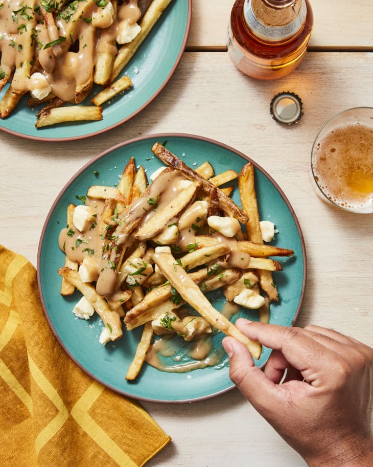 poutine on plate with napkin and beer