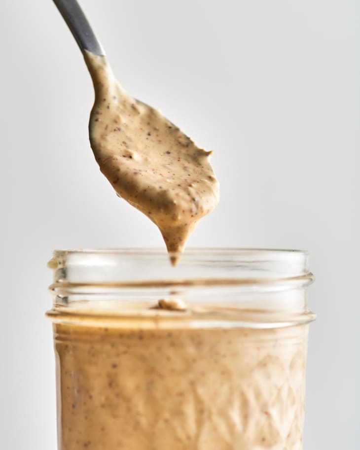 alabama white sauce in a jar with a spoon demonstrating texture