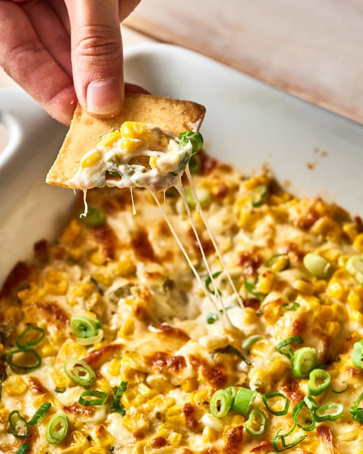 korean corn cheese dip in a casserole dish, a chip dipping