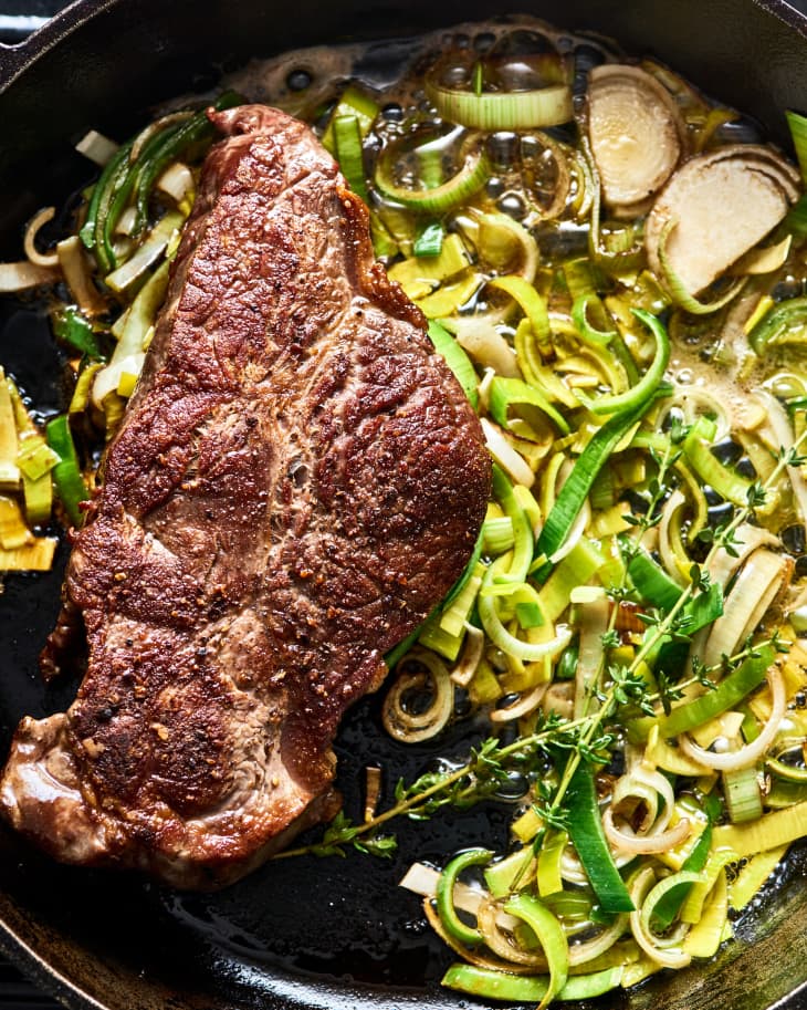 steak with melted leeks in the pan