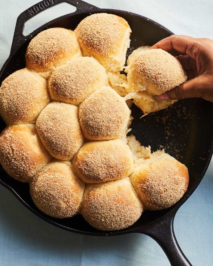 pandesal overhead in pan, one roll being pulled out