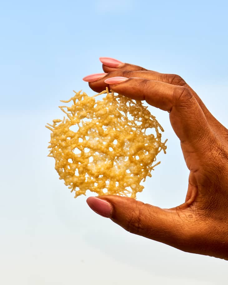 a parmesan crisp being held up to a window