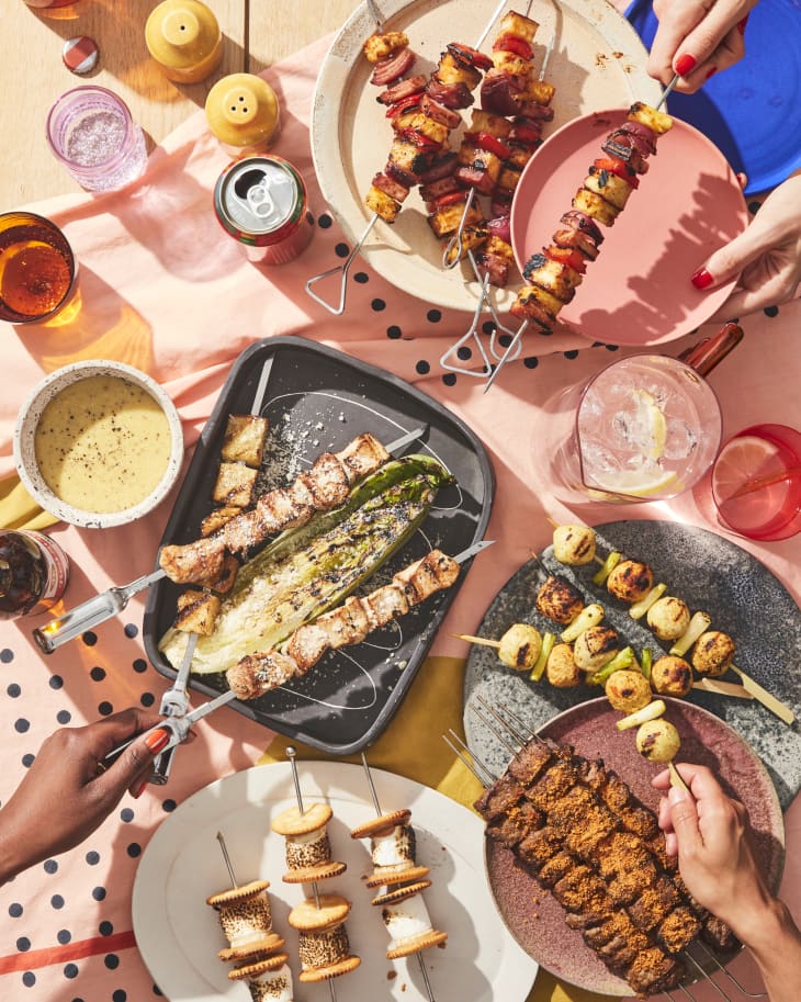 all of the types of skewers on a table with hands making and taking out skewers to eat