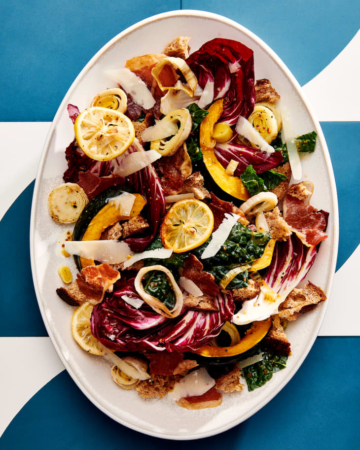 Fall Panzanella with Crispy leeks on white platter. Ble and white graphic background