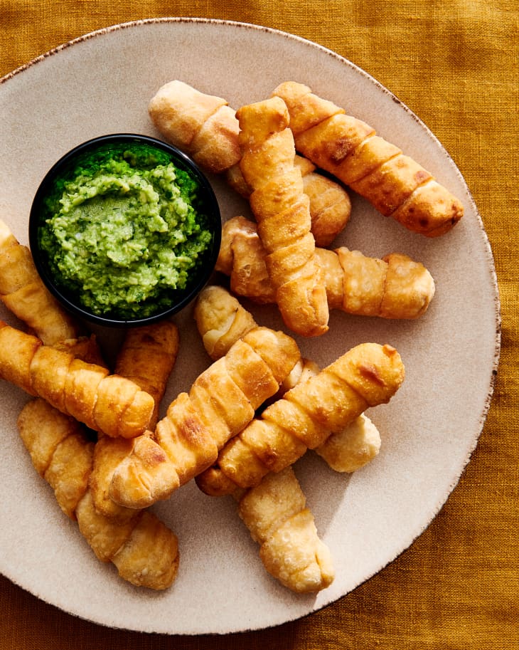 Venezuelan Cheese Sticks on ceramic plate with avocado dipping sauce.