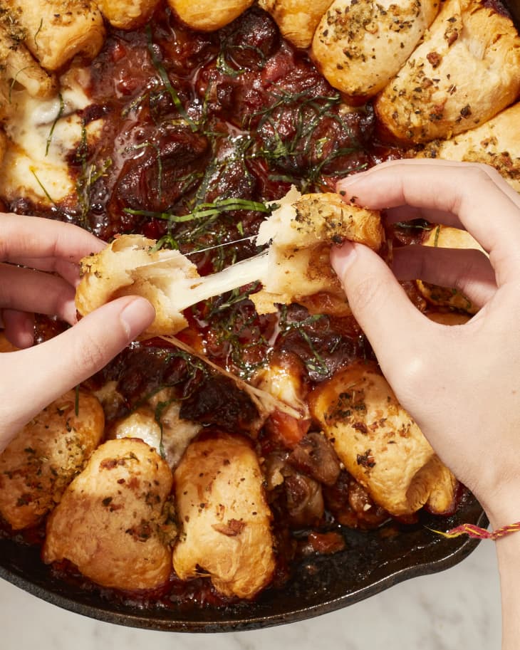 Someone pulling apart garlic butter bread.