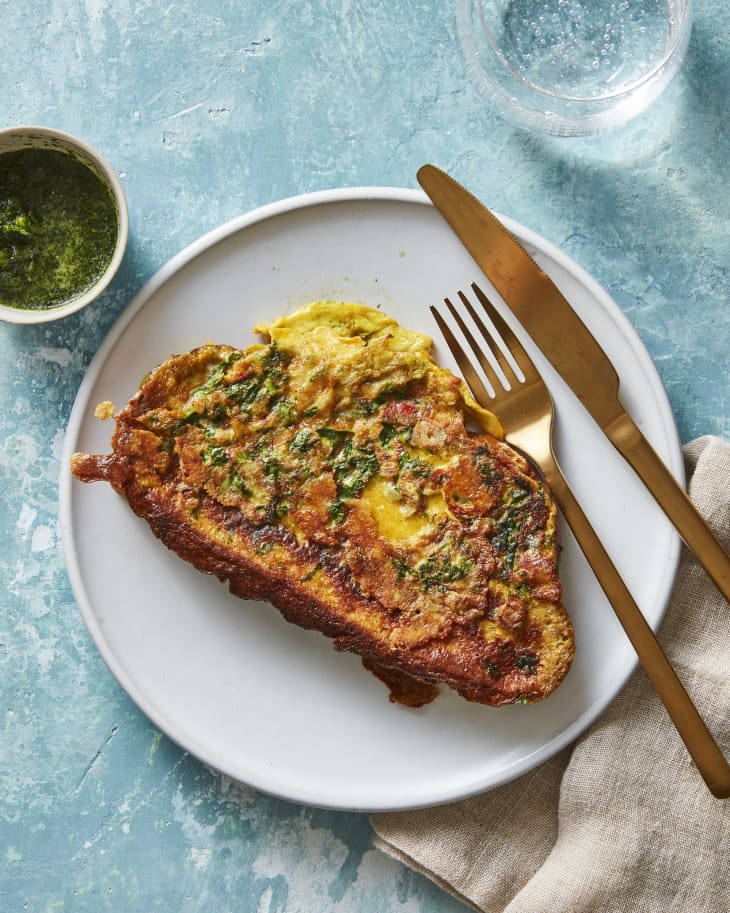 Overhead photo of Bombay Toast with sauce/garnish on plate. Fork and knife