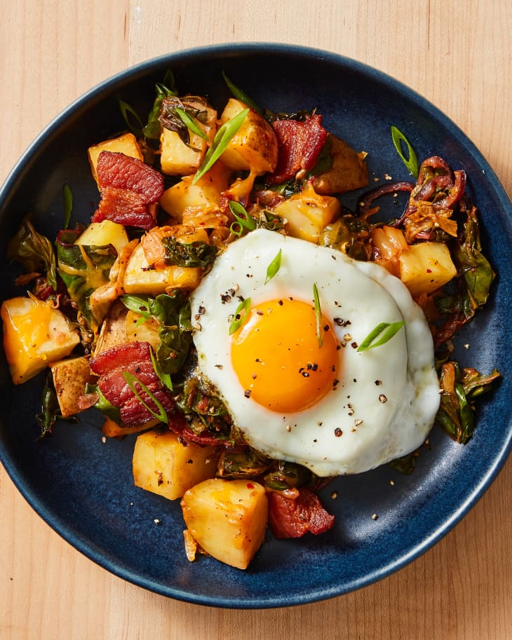 Overhead photo of cheesy kimchi breakfast skillet on plate with fried sunnyside up egg on top