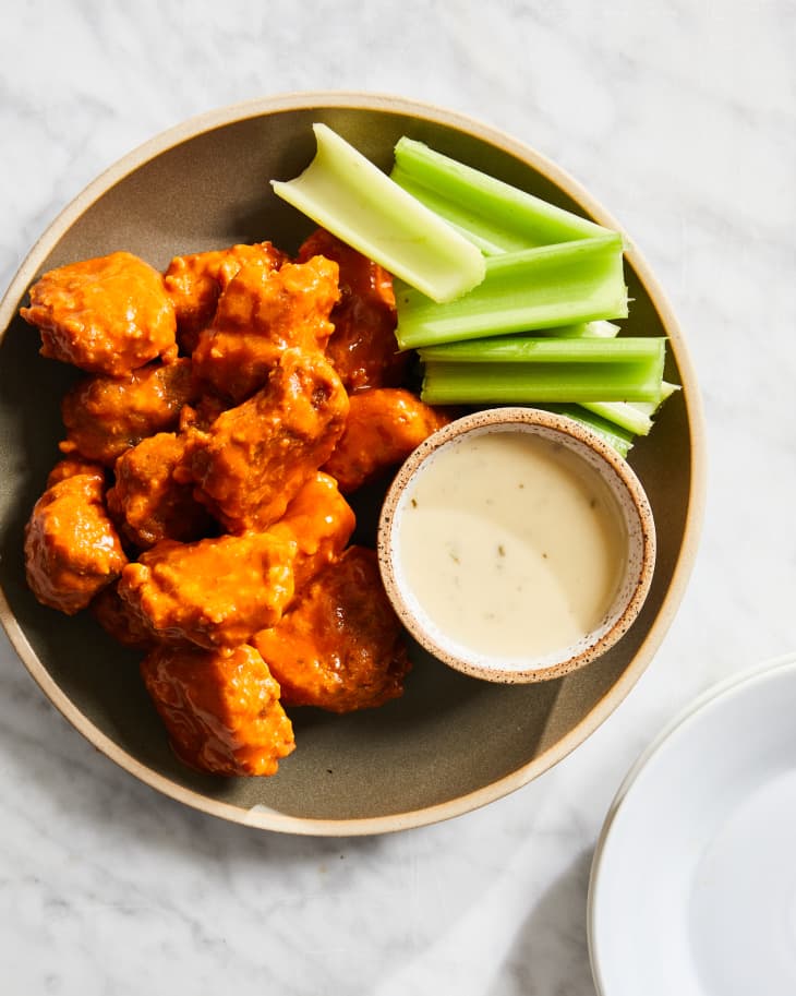 Vegan wings plated and served with vegan ranch and celery.