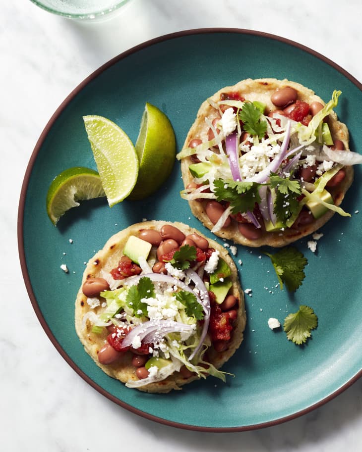 Sopes prepared and topped with beans and avocado