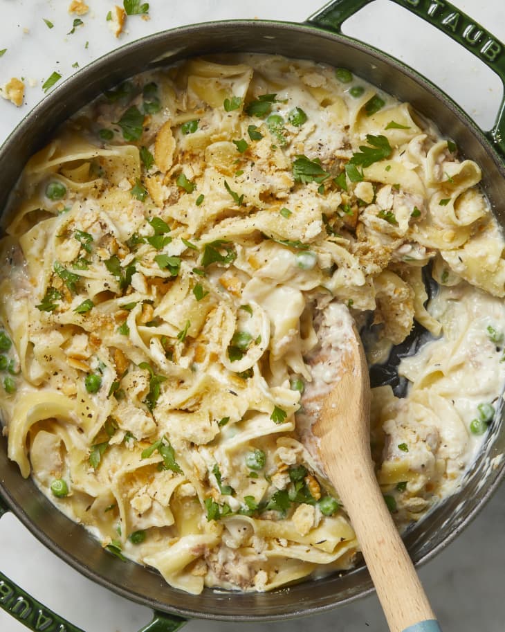 Overhead view of casserole in a dark green pot with a wooden spoon resting in it.