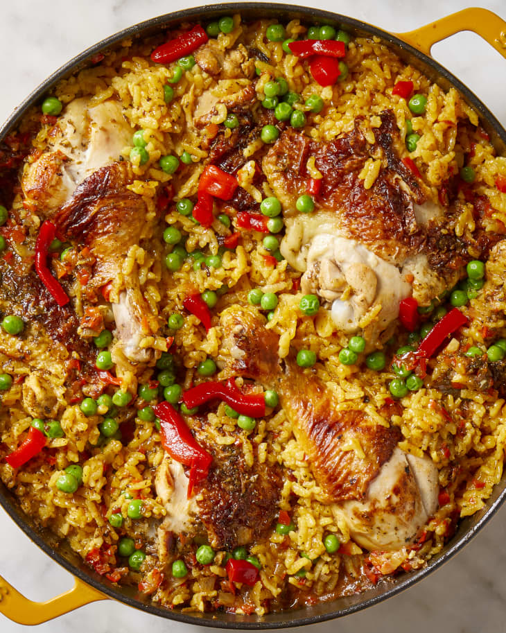 Close up view of arroz con pollo in a yellow baking dish.