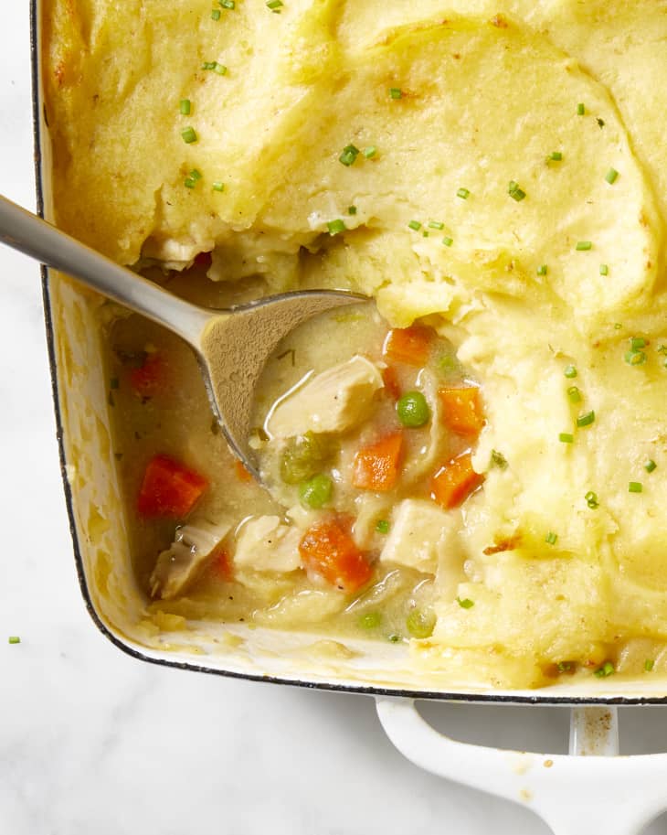 Close up view of the corner of the french chicken casserole with a scoop taken out of it.
