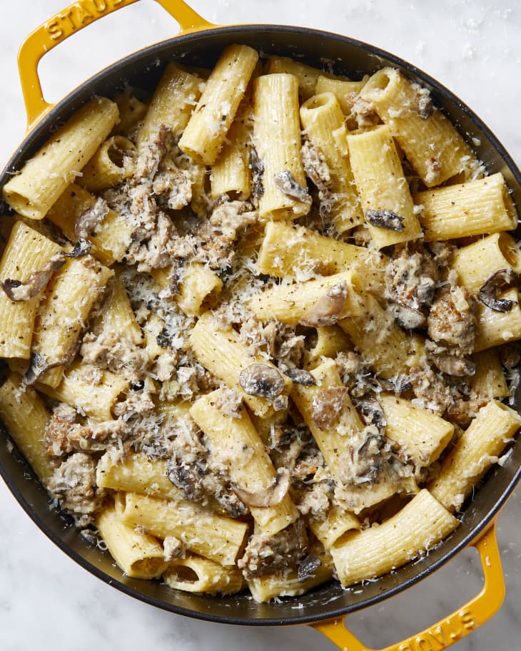 Overhead view of pasta in a pan topped with cheese.