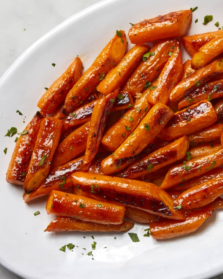 Overhead view of glazed carrots on a white platter.