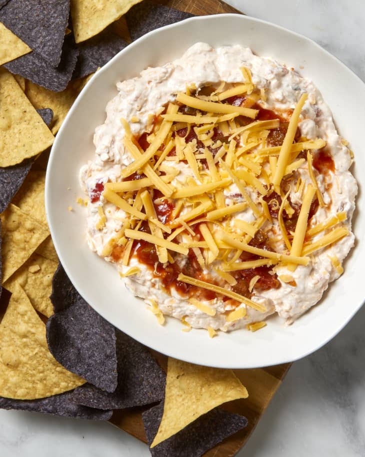 Overhead shot of southwest dip in a shallow white bowl with tortilla chips surrounding it.