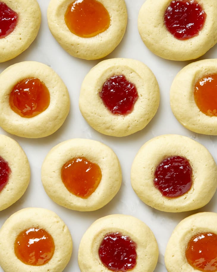 Overhead shot of thumbprint cookies on a white surface.