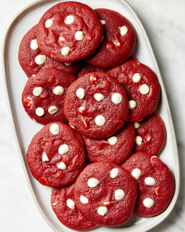 Overhead shot of red velvet cookies stacked on a white platter.