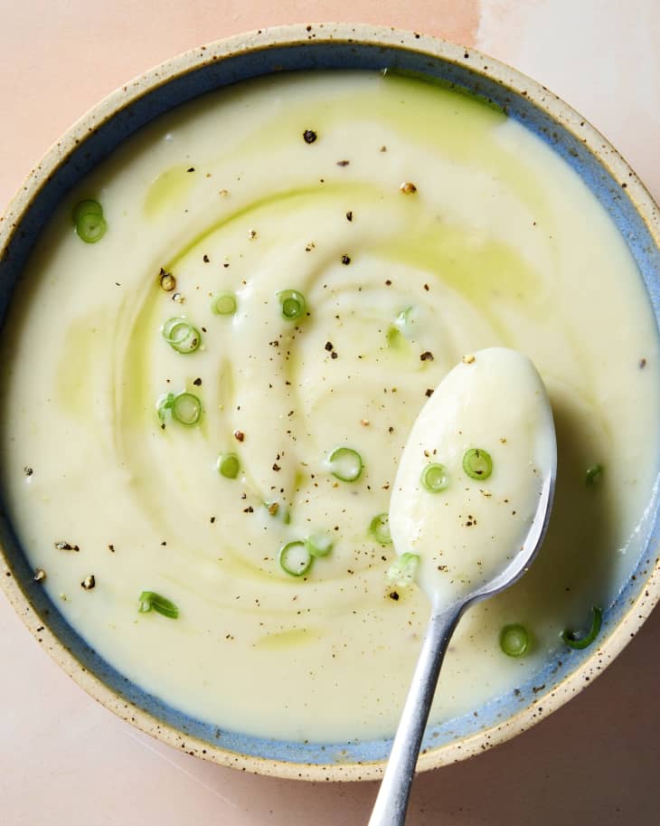 overhead shot of potato leek soup topped with chives and black pepper.