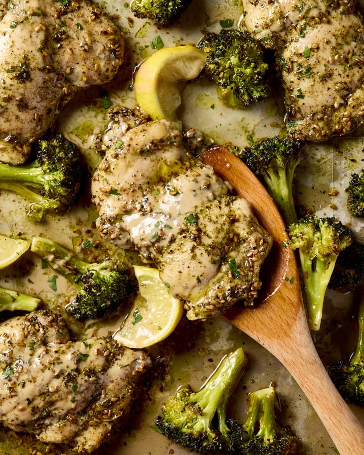 overhead shot of zaatar roasted chicken and broccoli on a sheet pan.