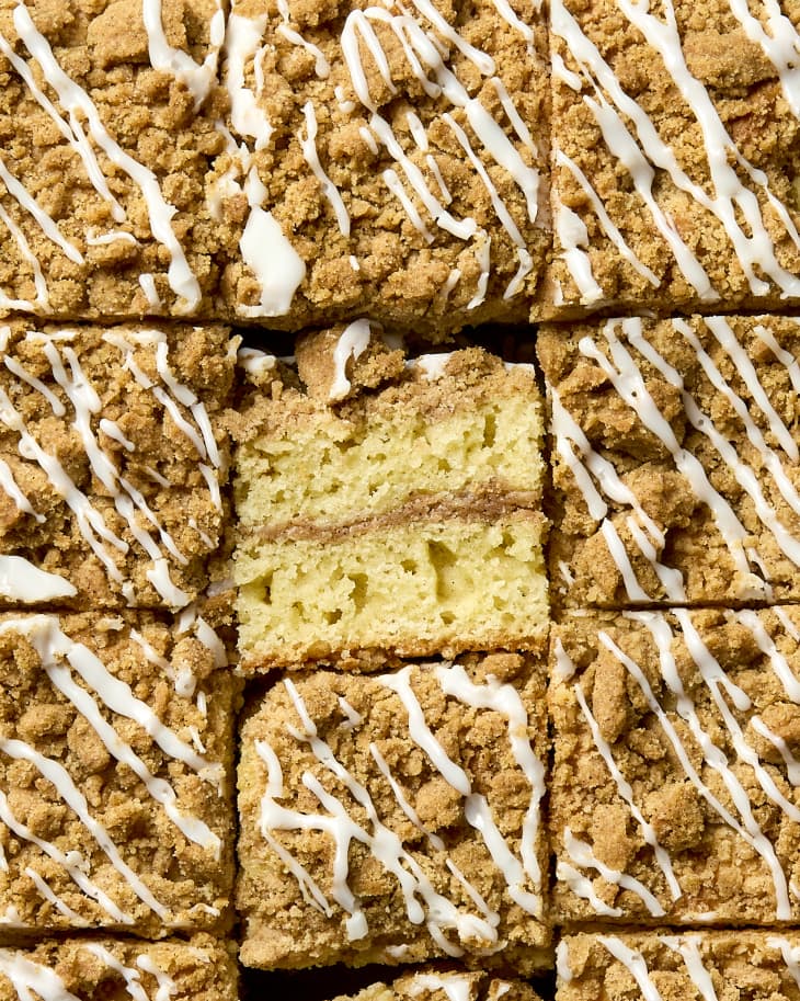 overhead shot of a full pan of coffee cake, with a piece in the middle turned up a bit facing the camera to show the layers.