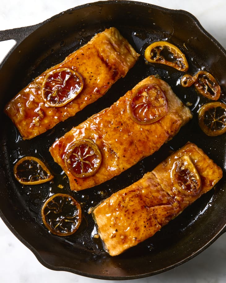 overhead shot of three pieces of lemon soy glazed salmon in a cast iron.