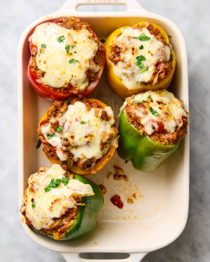 six stuffed peppers in baking dish, one missing