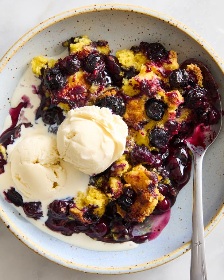 bowl of blueberry dump cake with ice cream in the center