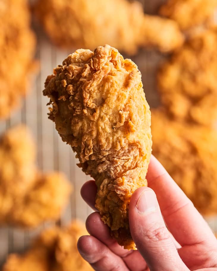 hand holding a fried chicken drumstick