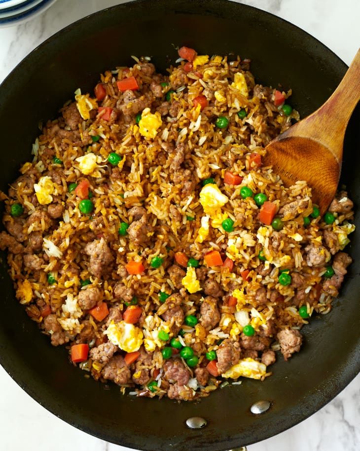 Pork fried rice in cooking pan with wooden spoon