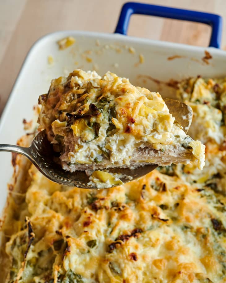 Spinach artichoke baked chicken on serving spoon.
