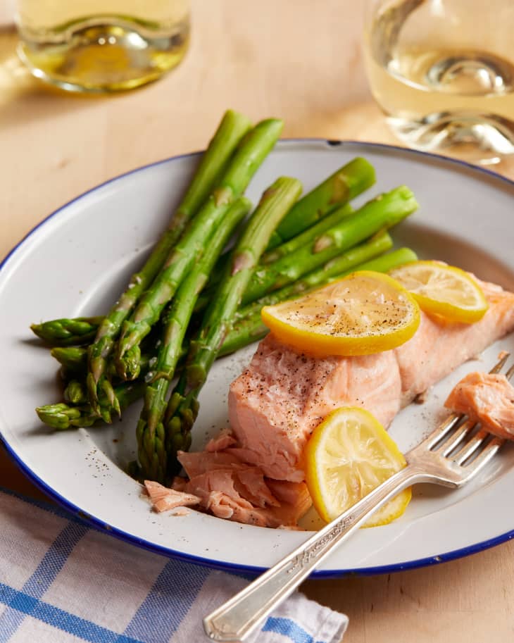 instant pot salmon is finished on a plate next to asparagus