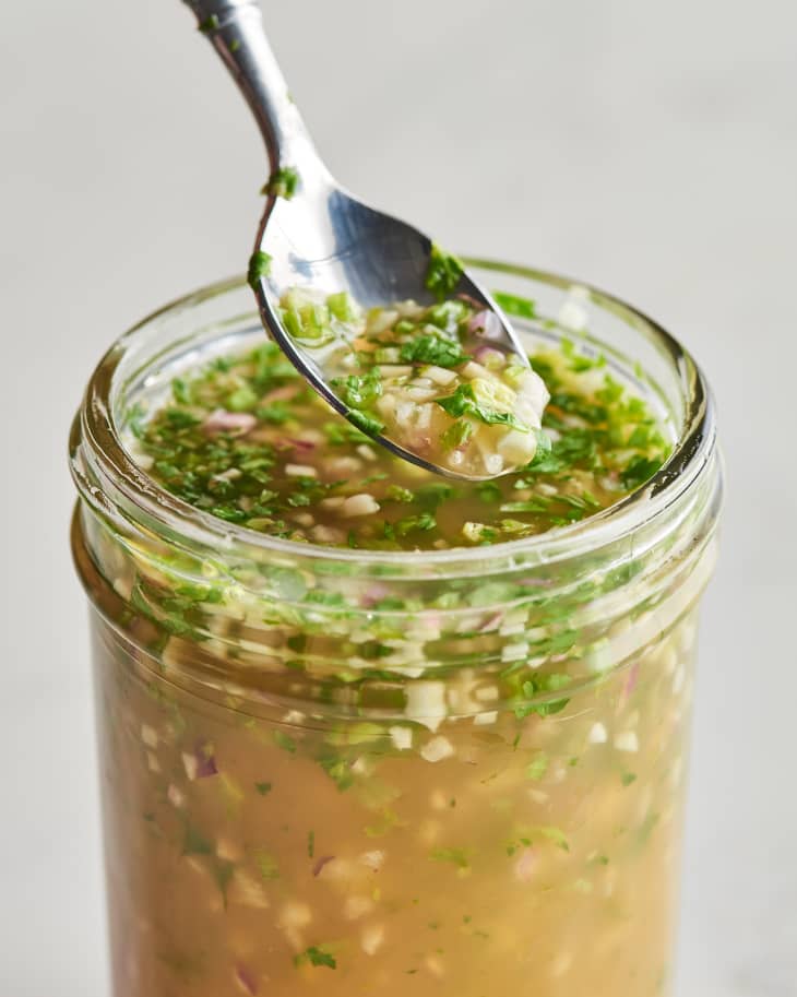 marinade in mason jar with some being taken out by spoon