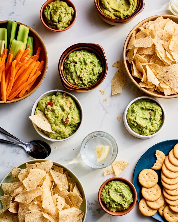 picture of a countertop filled with chips and littl ebowls of guacamole--a guac tasting party