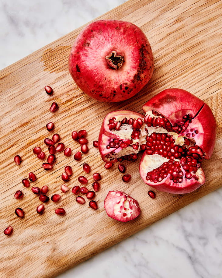 pomegranate on a cutting board with seeds