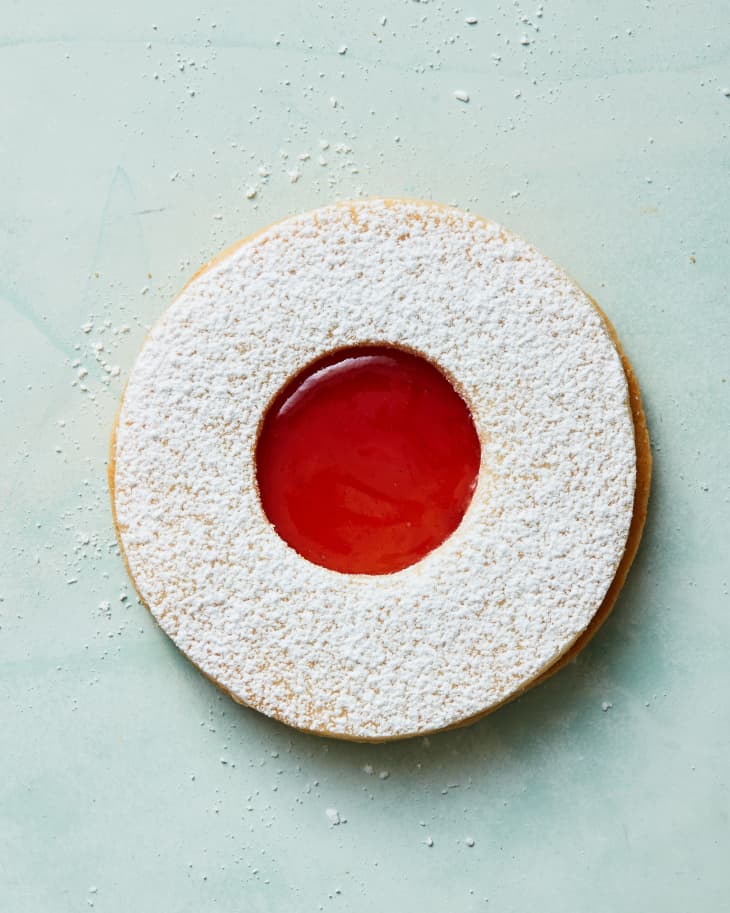 strawberry linzer cookie on a green surface