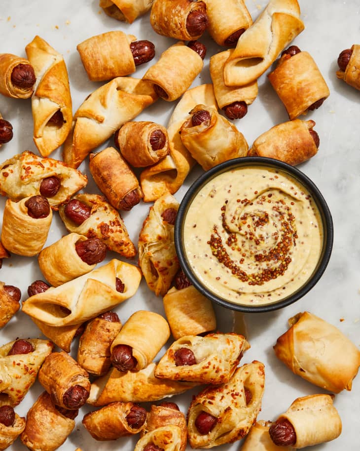 pigs in a blanket with sauce on a surface