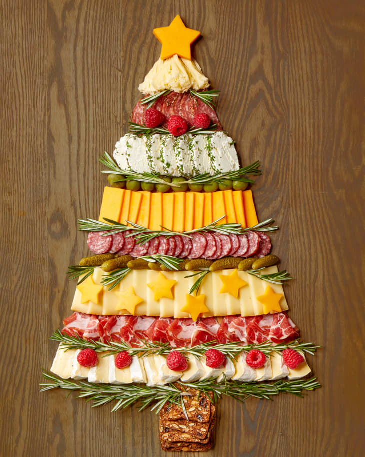 Overhead shot of a charcuterie board in the shape of a christmas tree, on a wooden board.